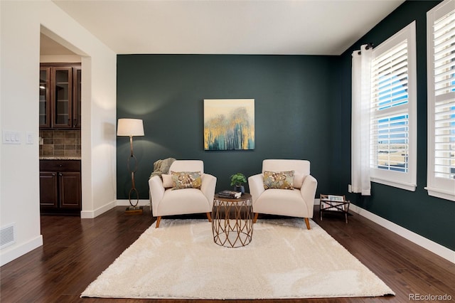 sitting room with a wealth of natural light and dark hardwood / wood-style floors