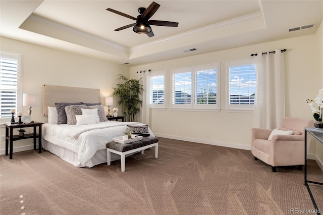 carpeted bedroom featuring ornamental molding, a tray ceiling, and ceiling fan