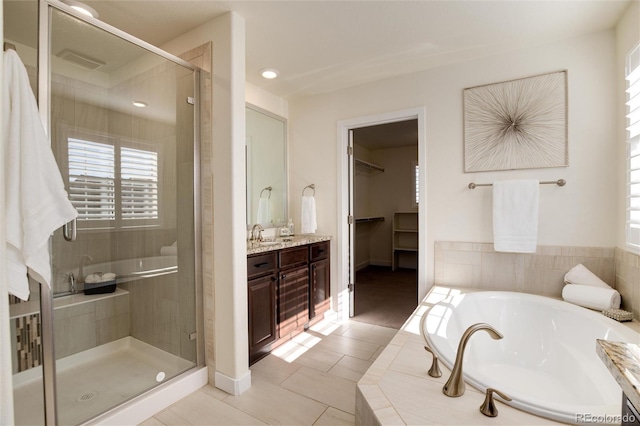 bathroom featuring vanity, tile patterned floors, and plus walk in shower