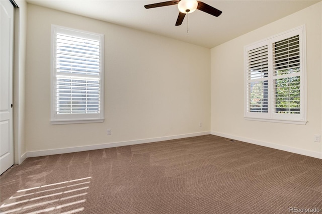 spare room featuring a wealth of natural light, ceiling fan, and carpet flooring