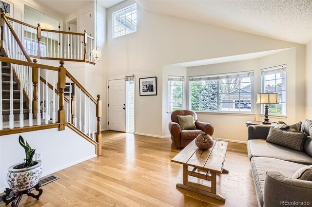 1641 Cedarwood Dr, Longmont, CO 80504 - living room featuring wood finished floors, stairs, high vaulted ceiling, and baseboards