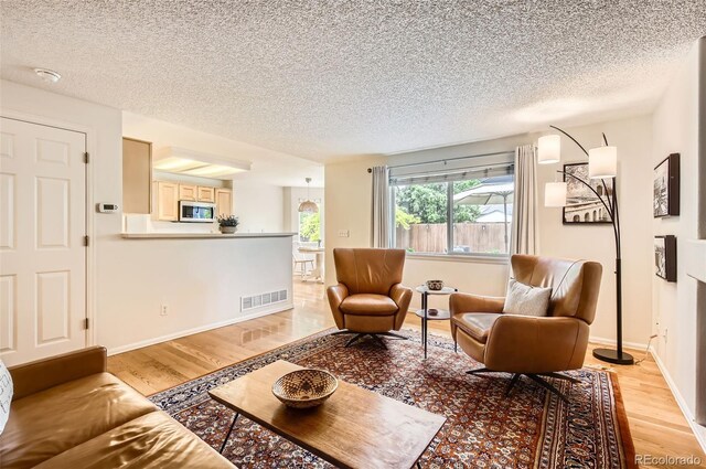 1641 Cedarwood Dr, Longmont, CO 80504 - living room with light wood finished floors, a textured ceiling, and baseboards