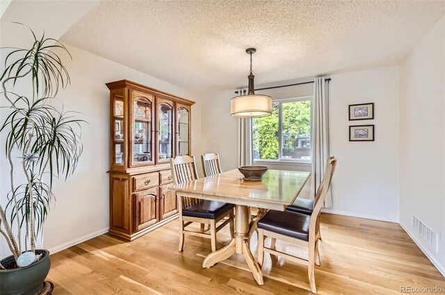 1641 Cedarwood Dr, Longmont, CO 80504 - dining area featuring a textured ceiling, light wood-style floors, and baseboards