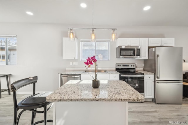 kitchen with a healthy amount of sunlight, white cabinets, and stainless steel appliances