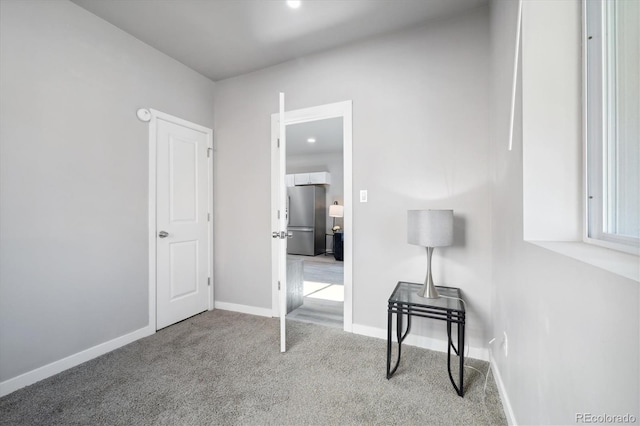 carpeted bedroom featuring stainless steel refrigerator