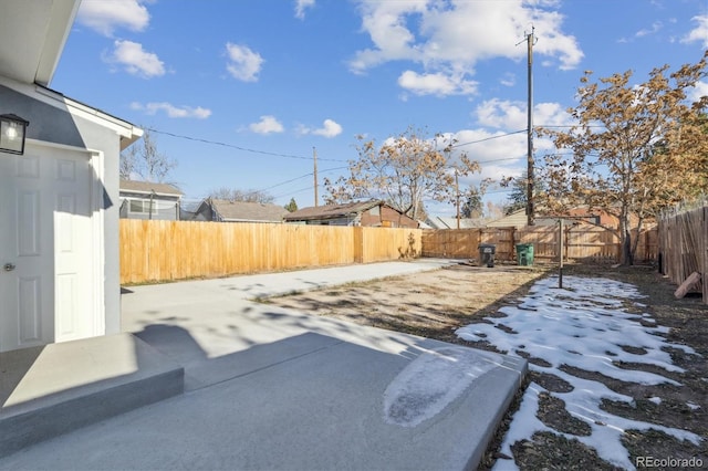 snowy yard featuring a patio area