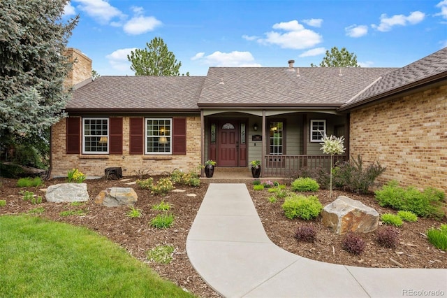 7881 S Ivy Ct, Centennial, CO 80112 - doorway to property featuring brick siding, covered porch, a chimney, and roof with shingles