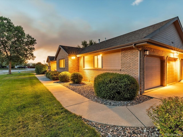 property exterior at dusk featuring a lawn and a garage