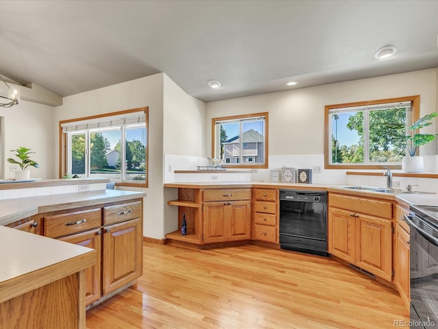 kitchen featuring black appliances, backsplash, plenty of natural light, and sink