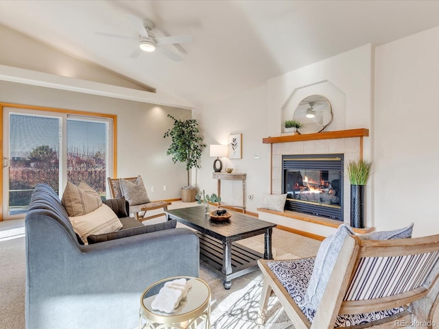 carpeted living room featuring ceiling fan, lofted ceiling, and a tile fireplace