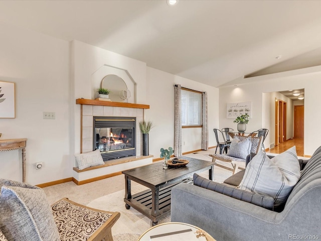 living room with light carpet, lofted ceiling, and a tiled fireplace