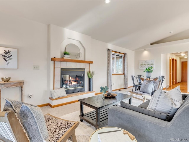 living room with light carpet, vaulted ceiling, and a tile fireplace