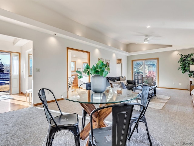 carpeted dining space with vaulted ceiling and ceiling fan