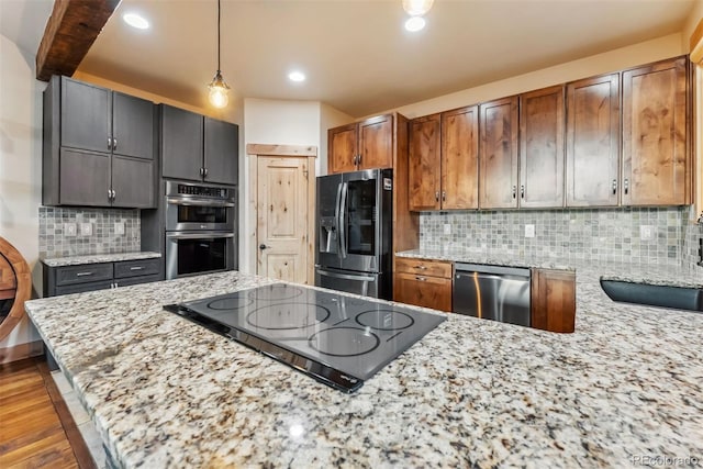 52 Buckskin Ln, Silverthorne, CO 80498 - kitchen featuring appliances with stainless steel finishes, light stone counters, decorative light fixtures, wood finished floors, and backsplash