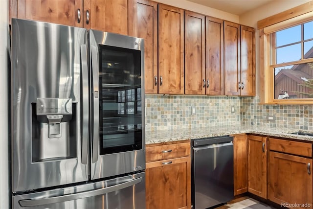 52 Buckskin Ln, Silverthorne, CO 80498 - kitchen with stainless steel fridge with ice dispenser, dishwashing machine, backsplash, brown cabinetry, and light stone countertops