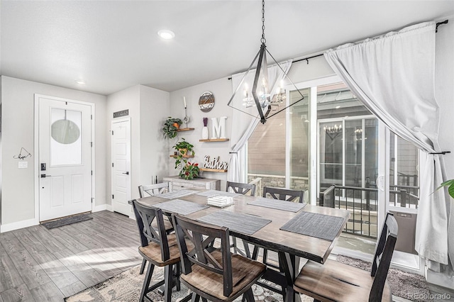 dining room with hardwood / wood-style floors and an inviting chandelier