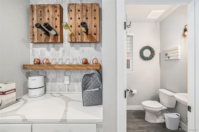 bathroom with hardwood / wood-style flooring and toilet