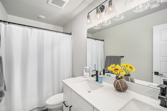 bathroom featuring vanity, walk in shower, and toilet