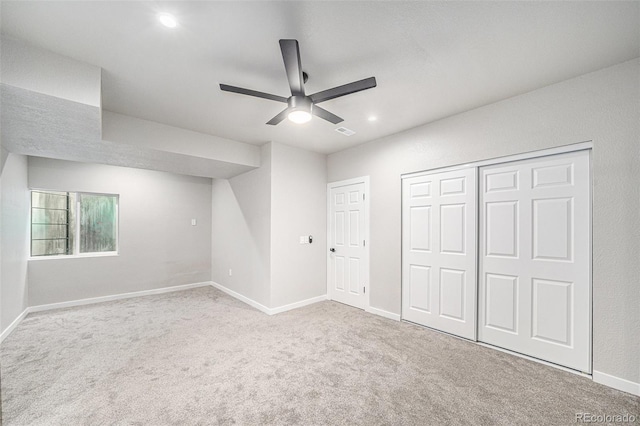 unfurnished bedroom featuring light colored carpet, a closet, and ceiling fan