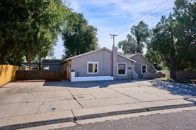 rear view of property featuring a patio area, fence, stucco siding, and a chimney
