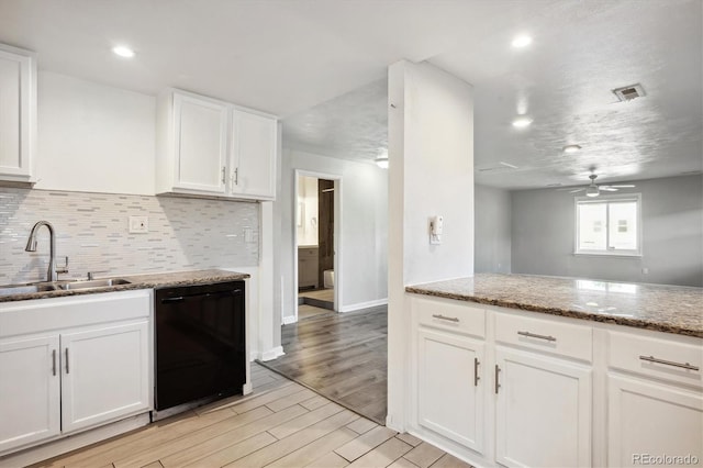 kitchen with stone counters, light wood-style flooring, a sink, white cabinets, and dishwasher