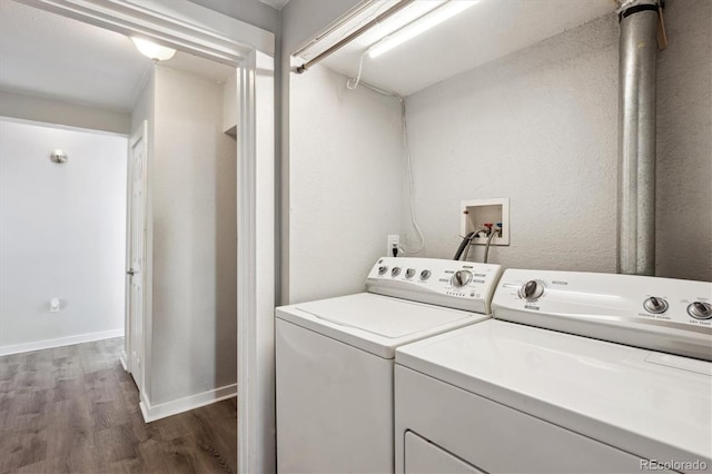 laundry area featuring separate washer and dryer, laundry area, baseboards, and wood finished floors