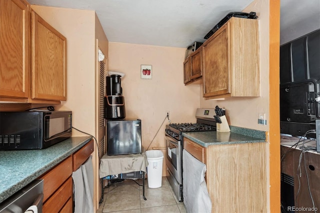 kitchen featuring dark countertops, appliances with stainless steel finishes, and light tile patterned floors