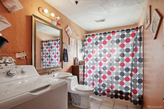 bathroom featuring washer / clothes dryer, visible vents, a sink, tile patterned floors, and a textured wall