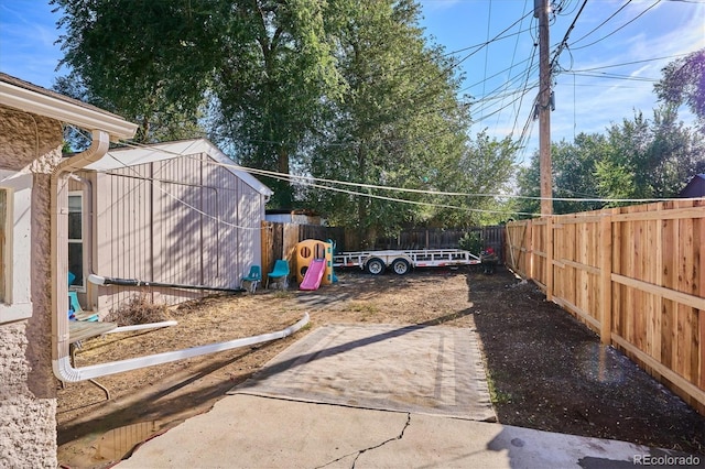 view of yard with a fenced backyard, an outdoor structure, and a shed