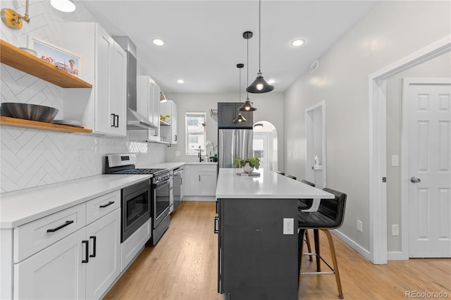 3443 Lawrence St, Denver, CO 80205 - kitchen featuring open shelves, appliances with stainless steel finishes, a breakfast bar area, light wood-style floors, and backsplash