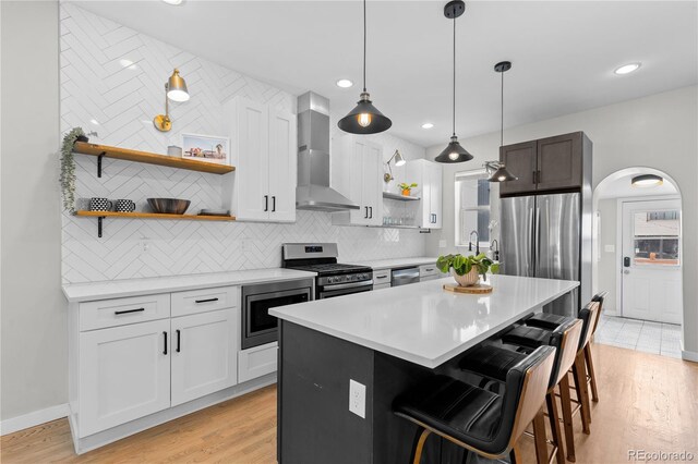 3443 Lawrence St, Denver, CO 80205 - kitchen with wall chimney exhaust hood, stainless steel appliances, open shelves, light countertops, and decorative backsplash