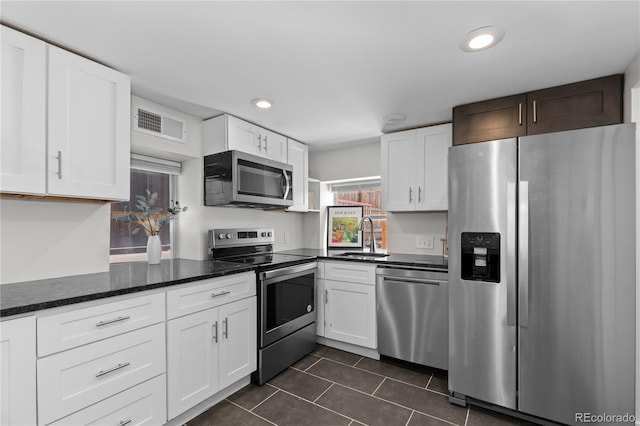 3443 Lawrence St, Denver, CO 80205 - kitchen with appliances with stainless steel finishes, dark tile patterned floors, white cabinets, and recessed lighting