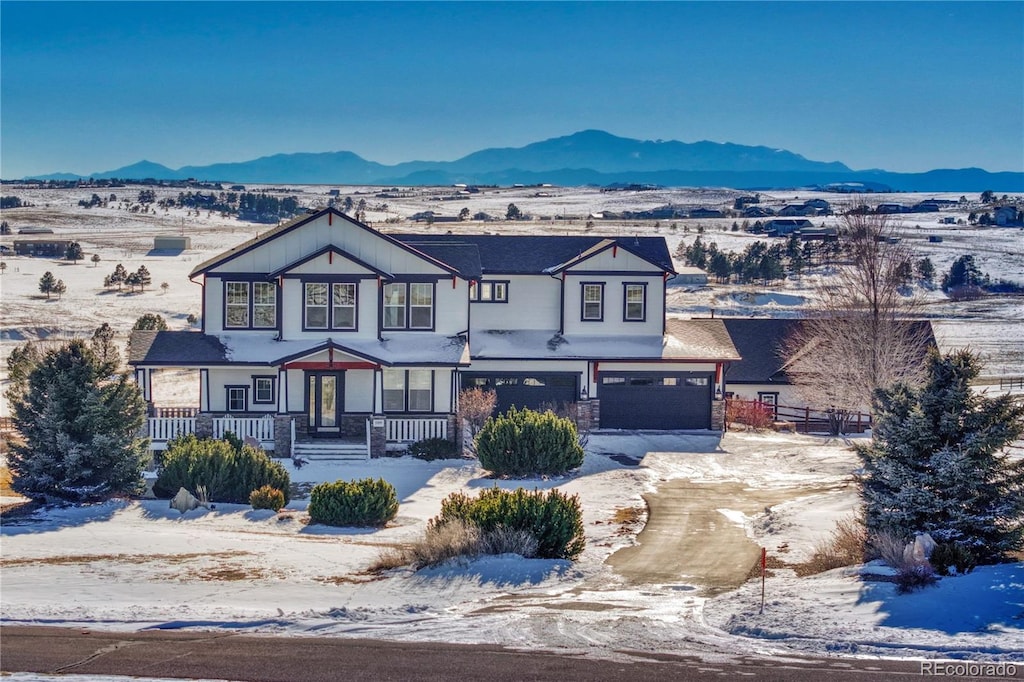 view of front facade featuring a garage, a porch, and a mountain view