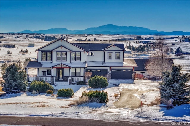 view of front of house featuring a garage, a mountain view, and covered porch