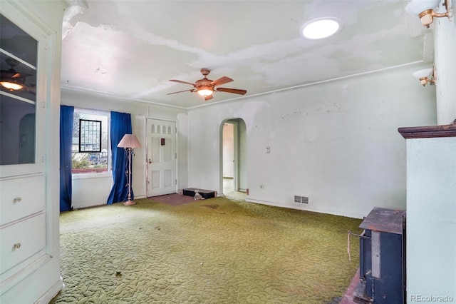 carpeted spare room with arched walkways, a ceiling fan, and visible vents