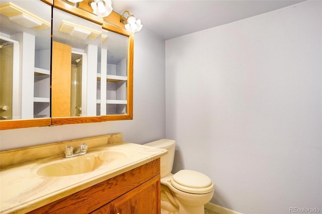 bathroom featuring vanity, baseboards, and toilet