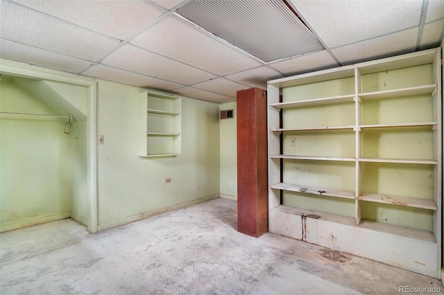 finished below grade area with baseboards, visible vents, and a paneled ceiling