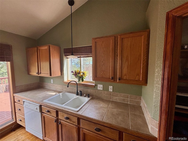 33508 Persistence Ave, Pine, CO 80470 - kitchen with white dishwasher, lofted ceiling, a textured wall, brown cabinetry, and decorative light fixtures