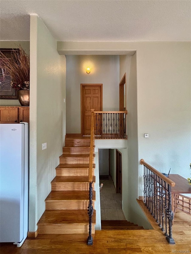 33508 Persistence Ave, Pine, CO 80470 - staircase featuring wood finished floors and a textured ceiling