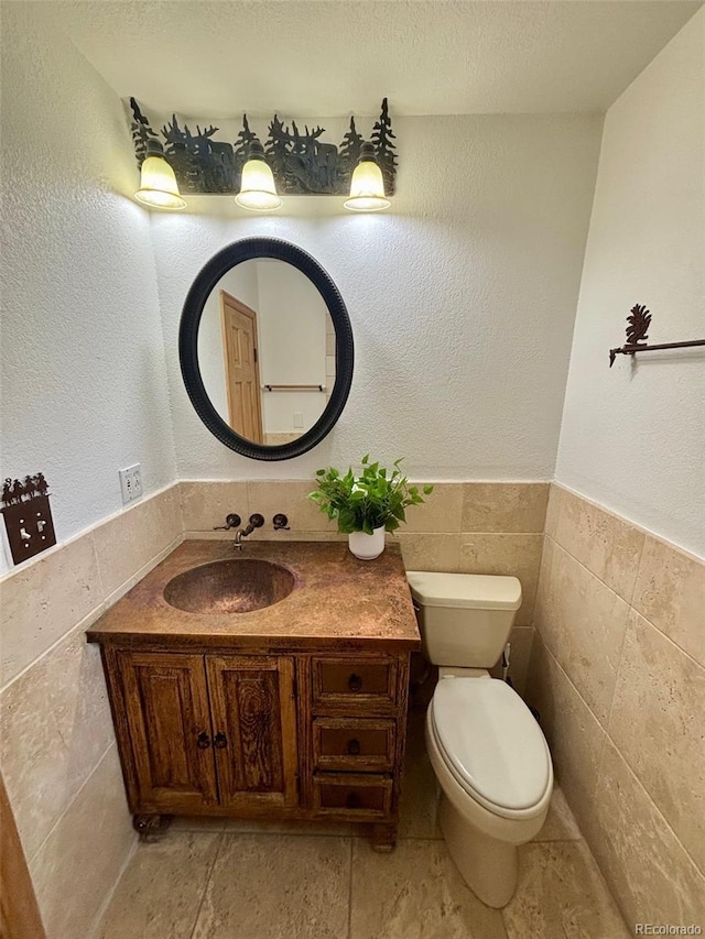 33508 Persistence Ave, Pine, CO 80470 - bathroom with tile walls, vanity, wainscoting, and a textured ceiling