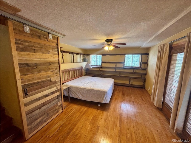 33508 Persistence Ave, Pine, CO 80470 - bedroom featuring a textured ceiling, light wood-style flooring, and ceiling fan