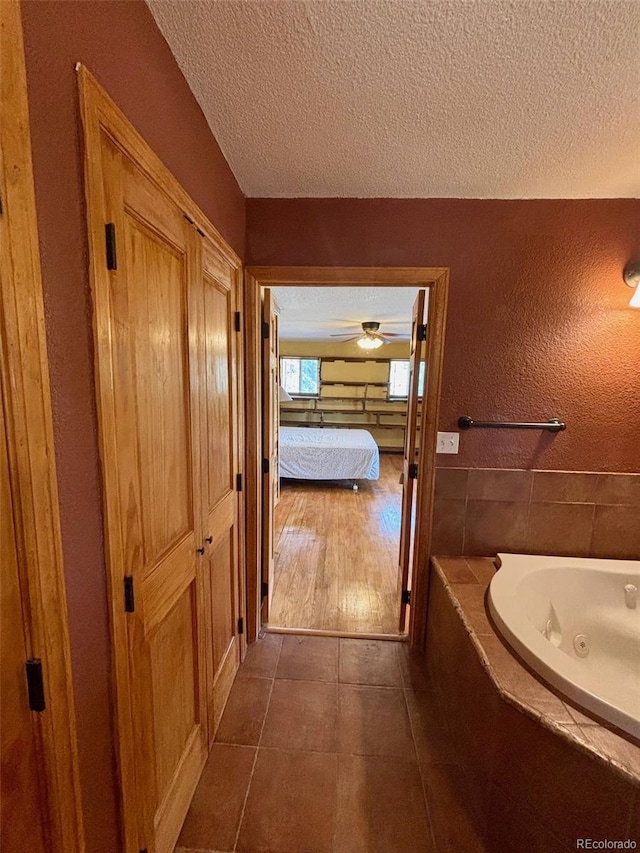 33508 Persistence Ave, Pine, CO 80470 - ensuite bathroom featuring a whirlpool tub, a textured ceiling, tile patterned flooring, and ceiling fan