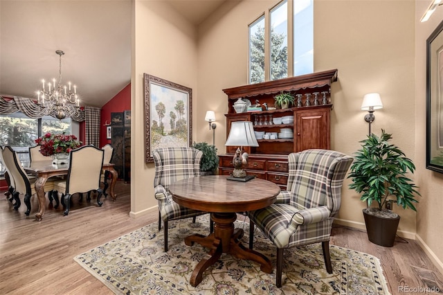 sitting room featuring vaulted ceiling, an inviting chandelier, and light hardwood / wood-style flooring