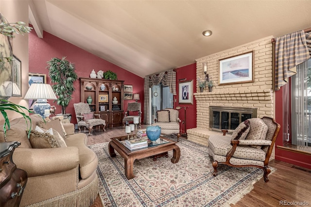 living room featuring lofted ceiling with beams, hardwood / wood-style floors, and a fireplace