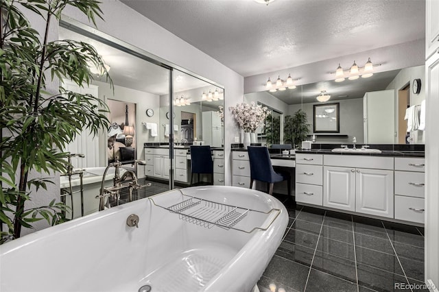 bathroom featuring vanity, a tub, tile patterned floors, and a textured ceiling