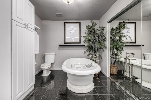 bathroom featuring a textured ceiling, a bathtub, and toilet