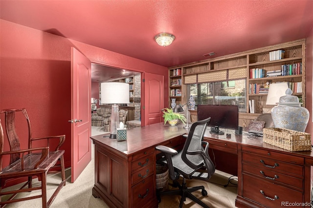 carpeted office featuring a textured ceiling