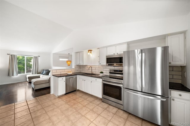 1482 S Pitkin Cir, Aurora, CO 80017 - kitchen with appliances with stainless steel finishes, dark countertops, vaulted ceiling, backsplash, and open floor plan