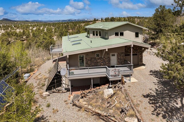 551 Spade Pl, Jefferson, CO 80456 - view of front of property featuring stone siding, metal roof, stucco siding, a view of trees, and stairway