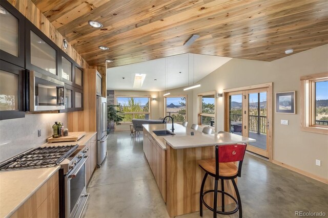 551 Spade Pl, Jefferson, CO 80456 - kitchen featuring appliances with stainless steel finishes, modern cabinets, finished concrete flooring, wood ceiling, and a spacious island